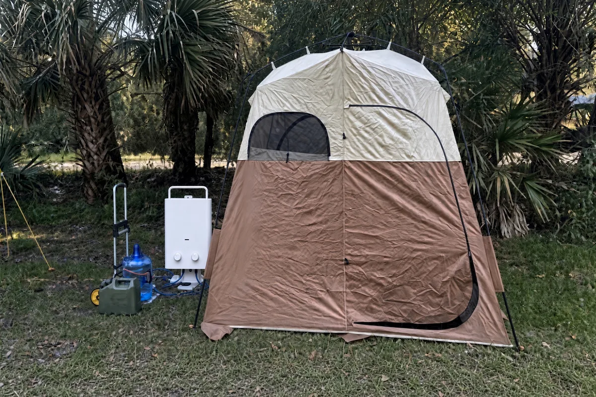 The 5L water heater set up at an off-grid tent site, fed from a water container