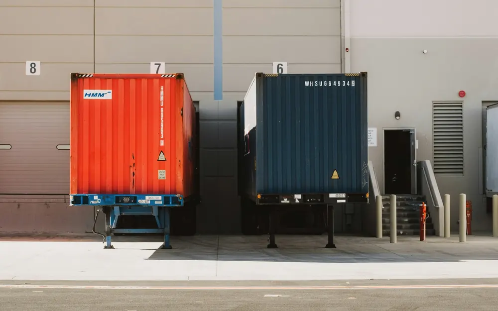 Shipping containers on the ground at a warehouse loading dock