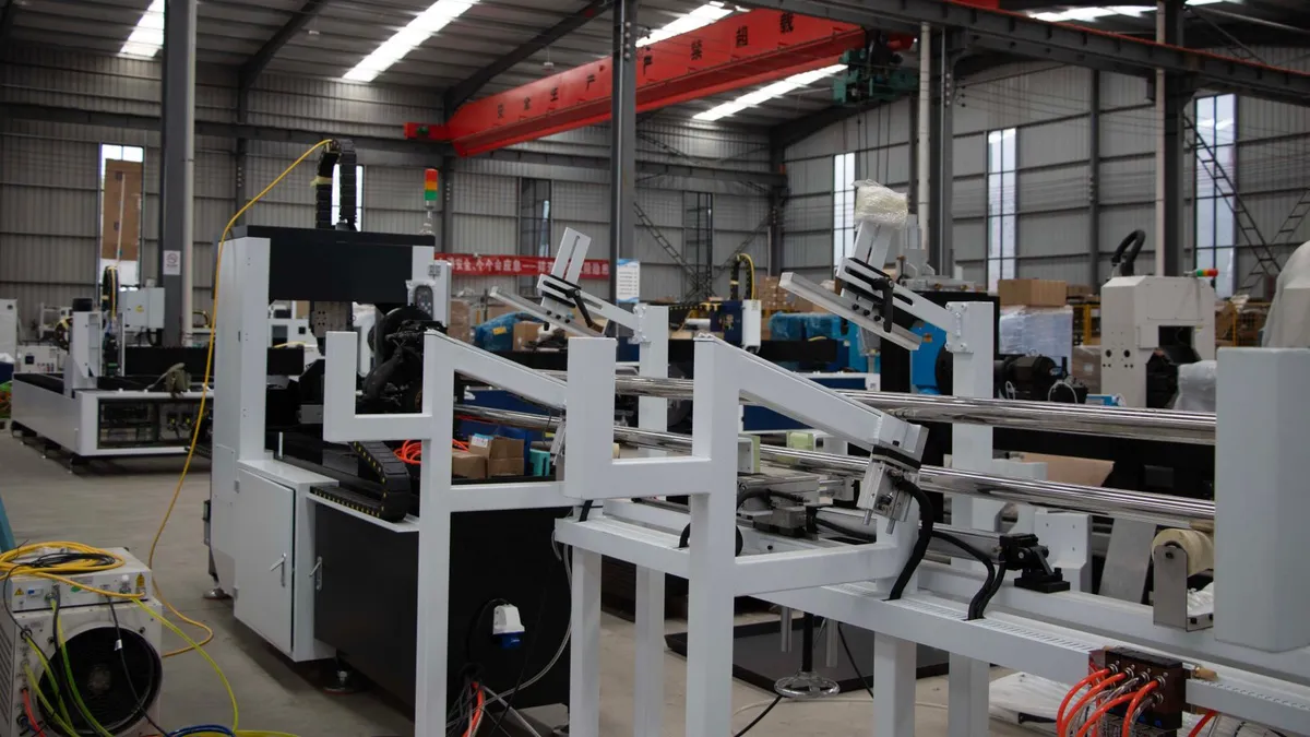 A production hall with an automated cutting machine and material conveyor