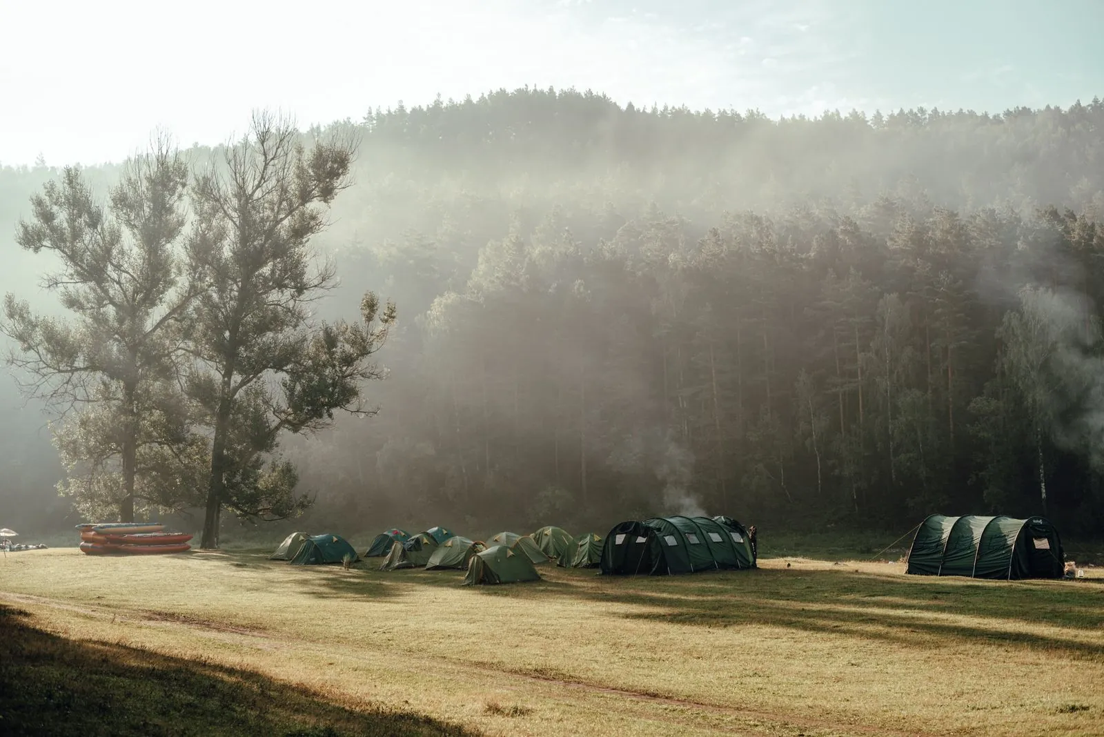 Campers at a misty off-grid camp with tents in the morning light