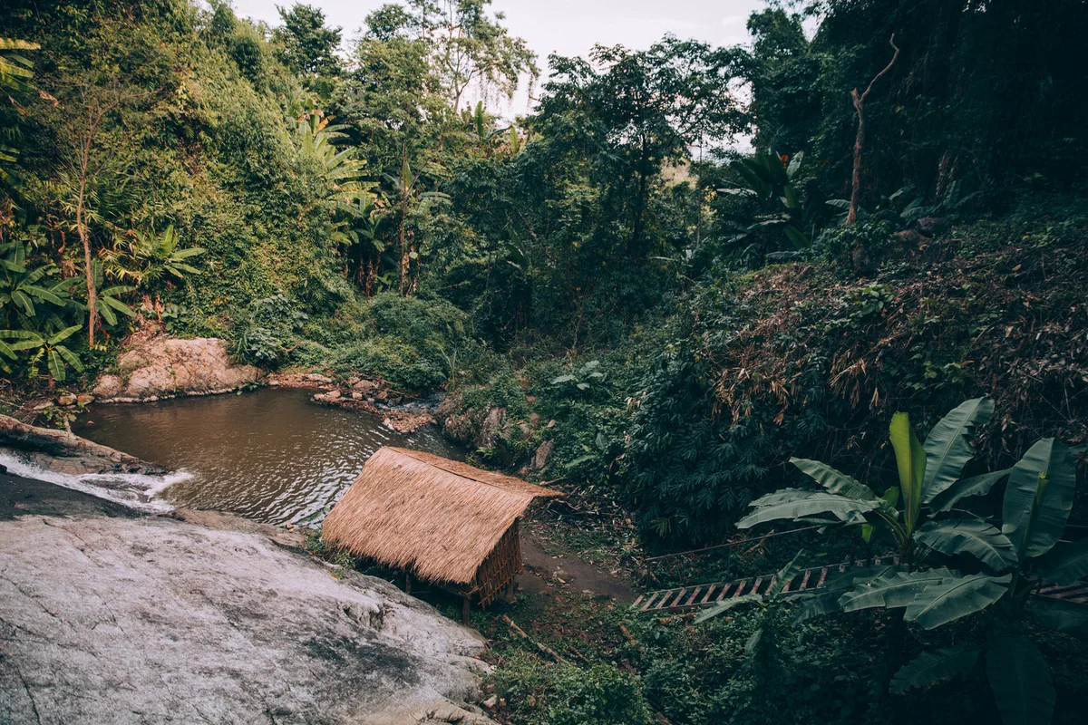 A small timber hut beside a pool of water
