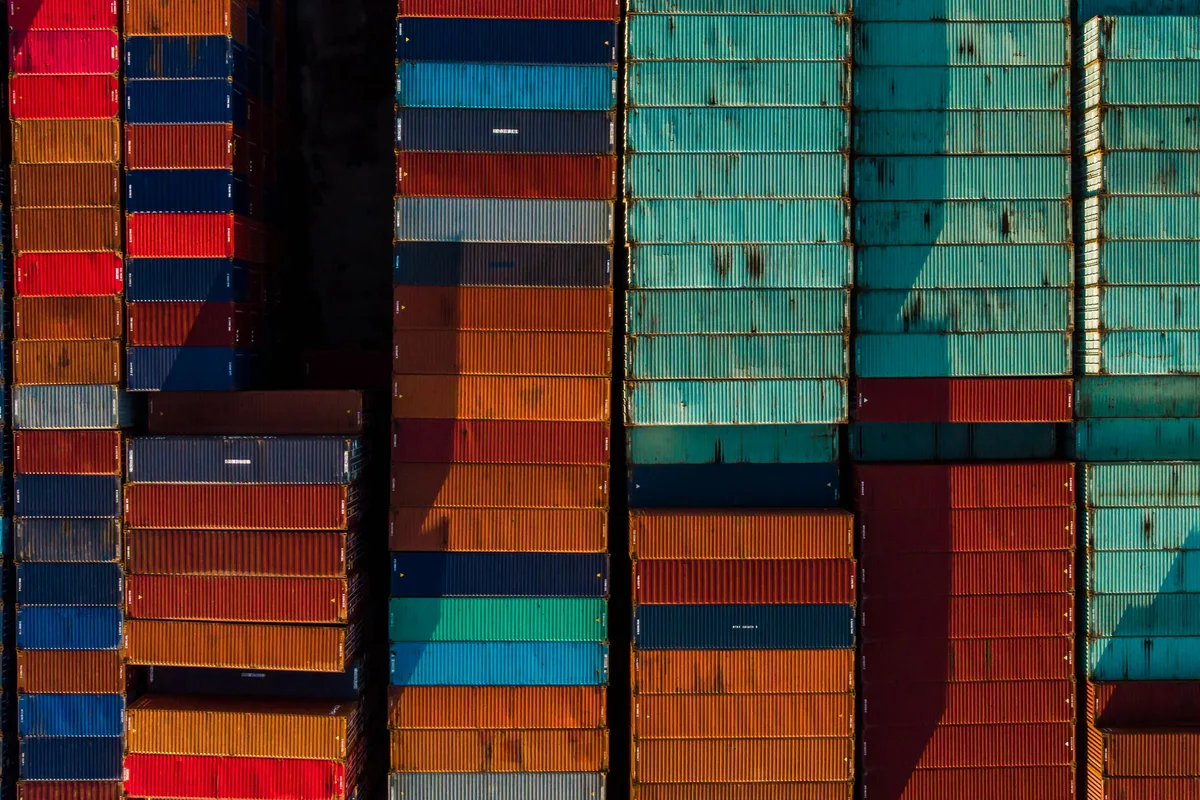 Rows of shipping containers seen from above in a freight yard