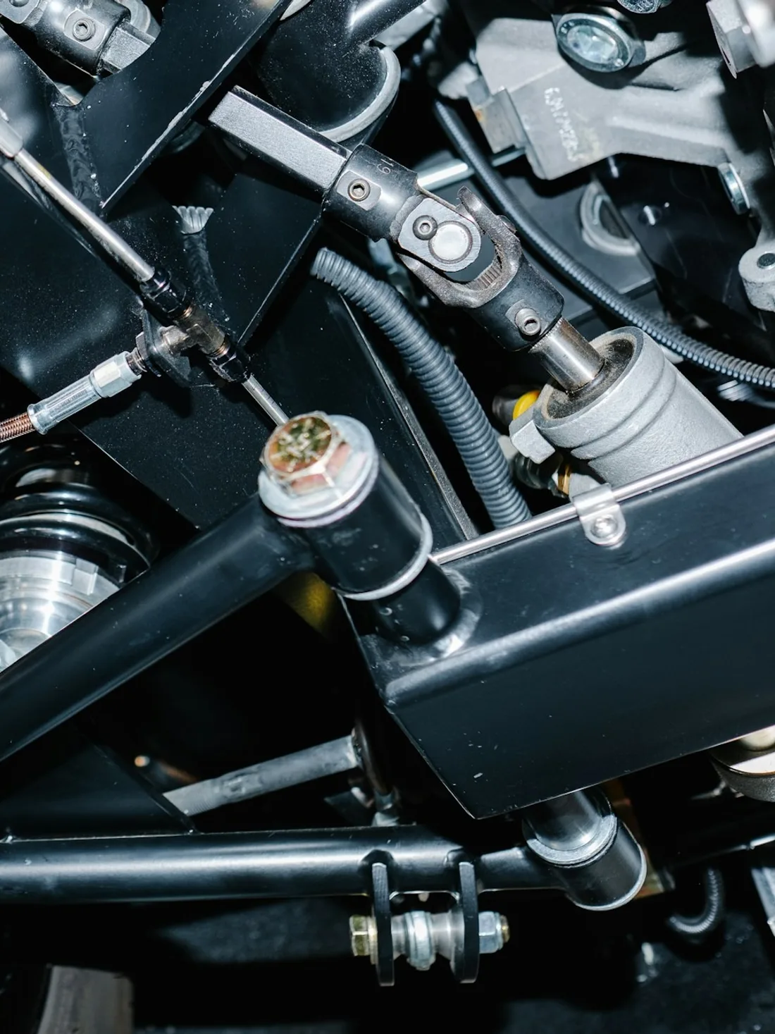 Close view of a four-wheel-drive chassis, suspension arm and shock absorber on rough ground