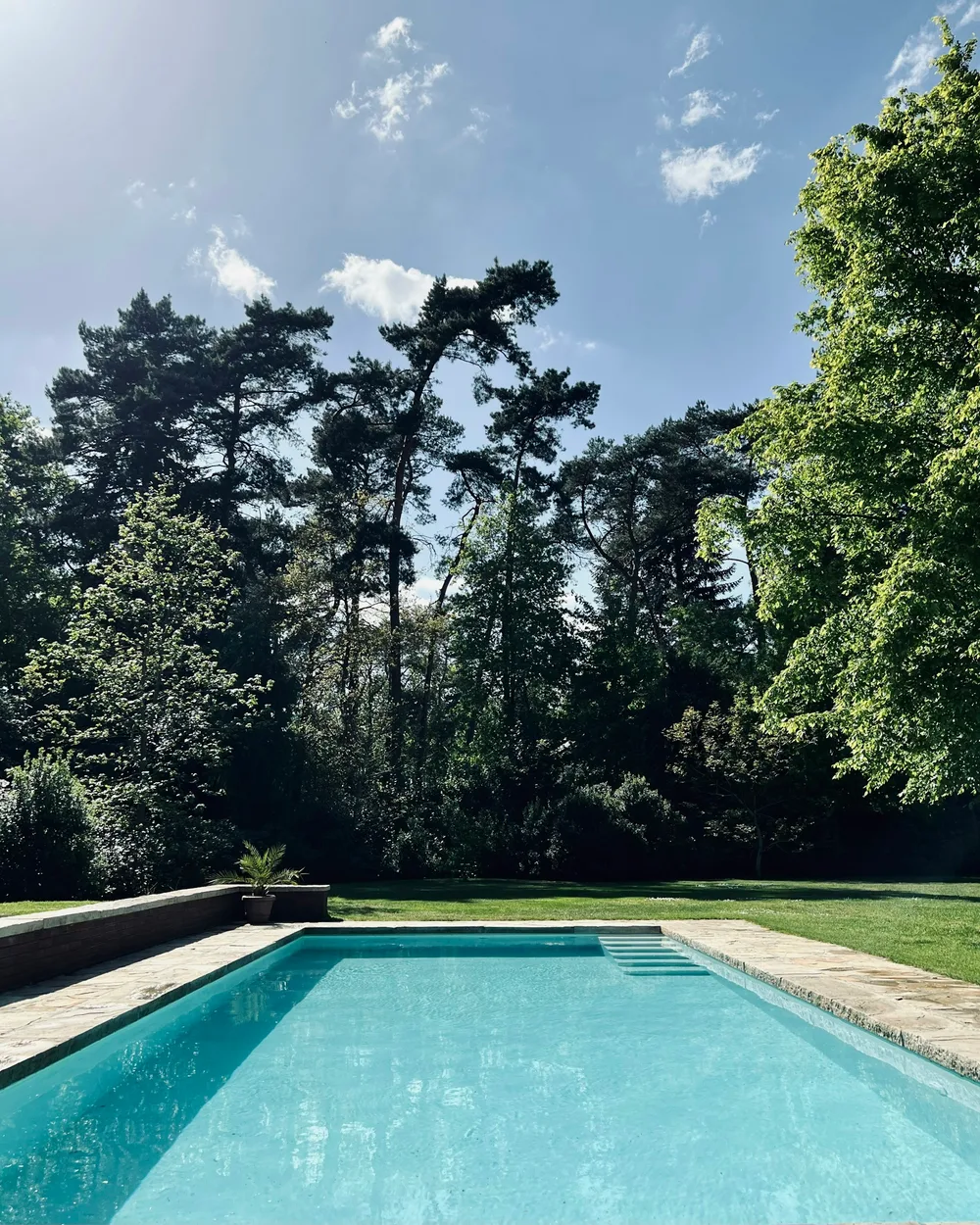 The edge of an outdoor swimming pool where a hot rinse point stands