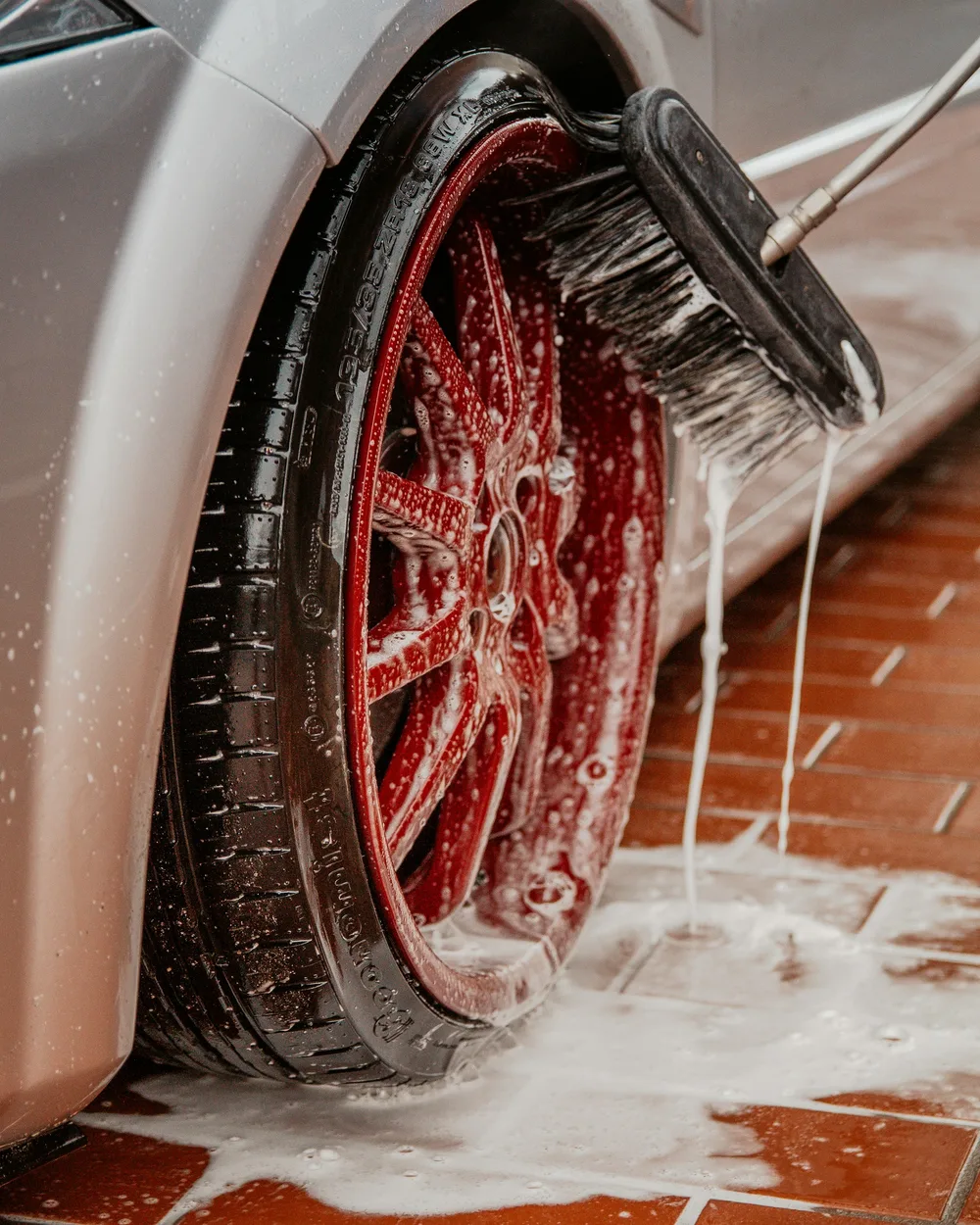 A vehicle wheel being hosed down in a yard wash bay