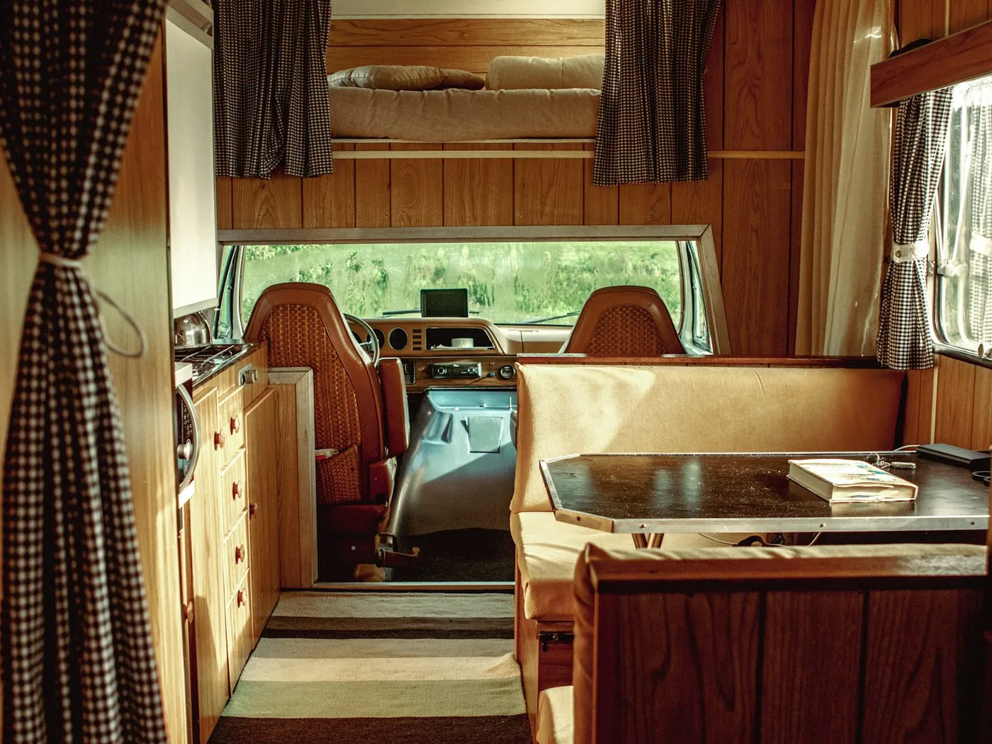 A camper dinette with bench seating and a window, the wall the unit is fitted behind