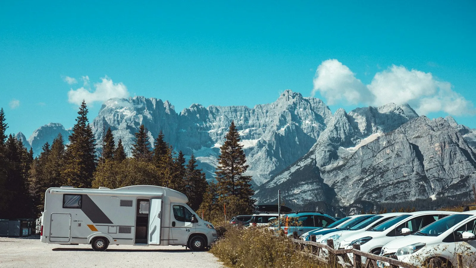 A camper parked below a mountain range, the kind of unserviced site the unit is built for