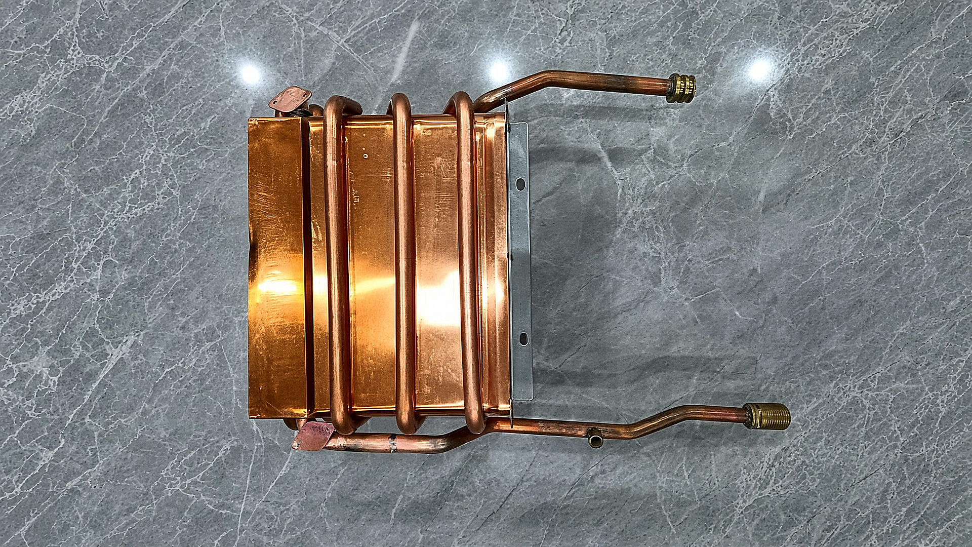 The Gulfstone RV water heater bypass heat exchanger: a TP2 oxygen-free copper coil brazed to a stainless mounting plate, with threaded inlet and outlet stubs